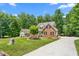 Beautiful two-story brick home with lush landscaping, mature trees, and a paved driveway at 1084 Wild Briar Ln, Stem, NC 27581