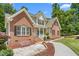 Charming brick home with well-maintained lawn, decorative landscaping, and a sidewalk at 1084 Wild Briar Ln, Stem, NC 27581