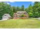 Stunning brick home with lush green lawn and mature trees in a serene setting at 1084 Wild Briar Ln, Stem, NC 27581