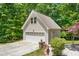 Detached two car garage with an apartment above it is surrounded by mature trees at 1084 Wild Briar Ln, Stem, NC 27581
