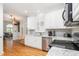 Beautiful open kitchen featuring white cabinets, stainless steel appliances and hardwood floors at 1084 Wild Briar Ln, Stem, NC 27581