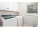 Functional laundry room equipped with modern washer and dryer, ample storage cabinets, and bright window at 1084 Wild Briar Ln, Stem, NC 27581