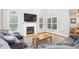 Inviting living room with a cozy fireplace, large windows, and plush seating area at 1084 Wild Briar Ln, Stem, NC 27581