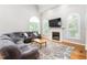 Spacious living room features a fireplace, abundant natural light, and a comfortable sectional sofa at 1084 Wild Briar Ln, Stem, NC 27581