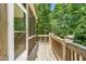 View of the screened-in porch leading to a wooden deck overlooking a vast backyard and lush greenery at 1084 Wild Briar Ln, Stem, NC 27581