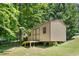 A backyard shed is framed by lush greenery, offering extra storage space and convenience on a manicured lawn at 1084 Wild Briar Ln, Stem, NC 27581