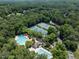 Aerial view of community amenities showcasing swimming pools, tennis courts, and lush greenery within a serene setting at 109 N Fern Abbey Ln, Cary, NC 27518