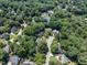An aerial view of a neighborhood, highlighting mature trees, community pool, tennis courts, and beautiful homes at 109 N Fern Abbey Ln, Cary, NC 27518