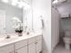 Bathroom featuring a double vanity with white cabinets and an adjacent toilet behind a half wall at 109 N Fern Abbey Ln, Cary, NC 27518