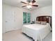 Bedroom featuring light carpet, a ceiling fan, and a classic wood headboard, creating a cozy retreat at 109 N Fern Abbey Ln, Cary, NC 27518