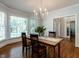 Elegant dining room with hardwood floors, stylish chandelier, and large windows that let in natural light at 109 N Fern Abbey Ln, Cary, NC 27518