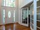 Bright foyer features hardwood floors, a soaring window, and white front door with glass panels at 109 N Fern Abbey Ln, Cary, NC 27518