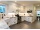 Bright kitchen with white cabinetry, stainless steel appliances, granite countertops and farmhouse style sink at 109 N Fern Abbey Ln, Cary, NC 27518