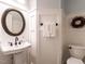 Cozy powder room featuring a pedestal sink, round mirror, and decorative wall accents at 109 N Fern Abbey Ln, Cary, NC 27518