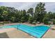 Large swimming pool with lap lanes and lounge chairs, surrounded by mature trees for shade and relaxation at 109 N Fern Abbey Ln, Cary, NC 27518