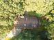 Aerial view of home featuring a brown roof, skylights, and a private drive surrounded by lush trees at 110 Wolfs Trl, Chapel Hill, NC 27516