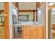 Wet bar featuring wooden cabinets, bar refrigerator, quartz counters and access to the Gathering room at 110 Wolfs Trl, Chapel Hill, NC 27516
