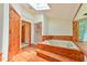 Bright bathroom featuring a sunken jacuzzi tub, natural lighting, wood flooring, and a walk-in shower at 110 Wolfs Trl, Chapel Hill, NC 27516