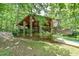 Exterior shot of a unique home design with stone pillars, wooden siding, and lush greenery at 110 Wolfs Trl, Chapel Hill, NC 27516