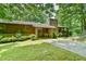 Front exterior showcasing a stone accented home with a sprawling driveway at 110 Wolfs Trl, Chapel Hill, NC 27516