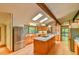 Sunlit kitchen features stainless steel appliances, wood cabinets, an island, and lovely views at 110 Wolfs Trl, Chapel Hill, NC 27516