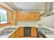 Close up shot of the kitchen sink and stovetop with light wood cabinets at 110 Wolfs Trl, Chapel Hill, NC 27516