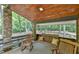 Cozy porch featuring a wooden swing, rocking chairs, stone pillars, and views of the surrounding greenery at 110 Wolfs Trl, Chapel Hill, NC 27516