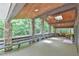 Large, inviting porch with stone columns, skylights, a wooden ceiling, and plenty of seating for outdoor enjoyment at 110 Wolfs Trl, Chapel Hill, NC 27516