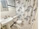 Bathroom with stylish black-and-white tile floor and decorative floral shower curtain at 1112 N Driver St, Durham, NC 27701