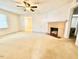 Bright living room featuring a ceiling fan and classic brick fireplace at 1112 N Driver St, Durham, NC 27701