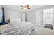 Cozy bedroom featuring a ceiling fan, grey carpet, and nearby bathroom at 1138 Ricochet Dr, Raleigh, NC 27610