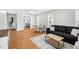 Bright living room featuring wood floors, a comfortable sofa, and a dining area with natural light at 1138 Ricochet Dr, Raleigh, NC 27610