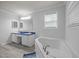 Bright bathroom featuring a soaking tub, double vanity with blue countertops, and ample light at 117 Lema Dr, Garner, NC 27529
