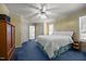 Cozy bedroom with blue carpet, light yellow walls, and a ceiling fan at 117 Lema Dr, Garner, NC 27529