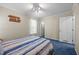 Comfortable bedroom with blue carpet, a decorative wooden cross on the wall and window at 117 Lema Dr, Garner, NC 27529