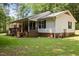 Charming single-story home with brick foundation, cozy front porch, lush lawn, and mature trees at 117 Lema Dr, Garner, NC 27529