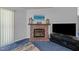 Close up of living room brick fireplace with mantel, television and cozy, inviting ambiance at 117 Lema Dr, Garner, NC 27529