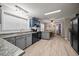 Well-lit kitchen featuring gray cabinetry, black appliances, and butcher block countertops at 117 Lema Dr, Garner, NC 27529