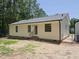 Rear of home shows vinyl siding, brick foundation, and a fenced in backyard at 117 Renee Dr, Smithfield, NC 27577