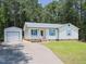 Charming single-story home with white siding, blue shutters, and a detached garage at 117 Renee Dr, Smithfield, NC 27577