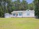 Exterior shot of charming single story home with white siding, blue shutters, and a detached garage at 117 Renee Dr, Smithfield, NC 27577