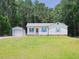 Charming single-story home featuring blue shutters, white siding, and a spacious front yard at 117 Renee Dr, Smithfield, NC 27577