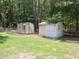 This view shows two backyard storage sheds with neutral paint schemes at 117 Renee Dr, Smithfield, NC 27577