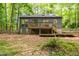 Exterior view of home showcasing the backyard with a deck, stairs, and natural landscaping at 120 Polks Landing Rd, Chapel Hill, NC 27516