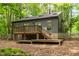 Exterior view of home from backyard featuring a deck, stairs, and natural landscaping at 120 Polks Landing Rd, Chapel Hill, NC 27516
