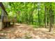 Exterior view from backyard with a deck, stairs, mature trees, and landscaping at 120 Polks Landing Rd, Chapel Hill, NC 27516