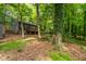 Rear view of house featuring a deck and mature trees in a natural backyard setting at 120 Polks Landing Rd, Chapel Hill, NC 27516