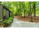 Secluded backyard with lush trees, offering a serene outdoor space and pathway to the surrounding nature at 120 Polks Landing Rd, Chapel Hill, NC 27516