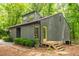 Charming home with a bright yellow door and wood steps surrounded by lush trees at 120 Polks Landing Rd, Chapel Hill, NC 27516
