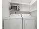 Laundry room featuring a washer, a dryer and overhead shelving for convenience at 120 Polks Landing Rd, Chapel Hill, NC 27516
